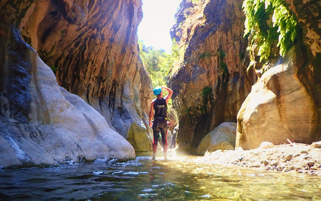 Man looking at the entrance of a canyon.