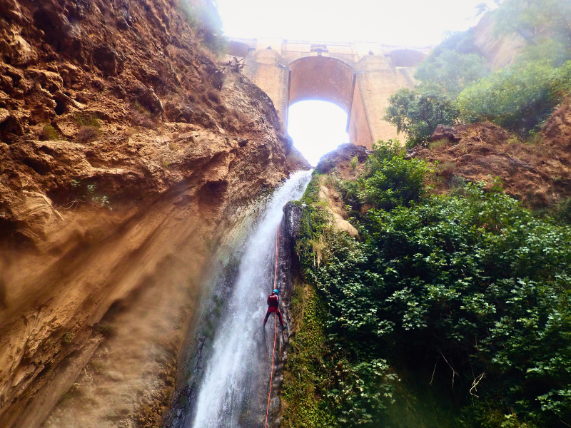 A person rappelling down a waterfall of 36 metres in height, under the "New Bridge" of Ronda (a rock bridge built in the XVII century).